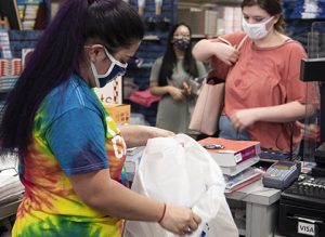 Students wearing masks are checking out at the bookstore.